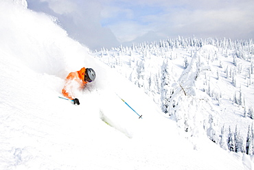 Male Skier Makes A Deep Powder Turn In Snowy Landscape At Whitefish, Montana, Usa