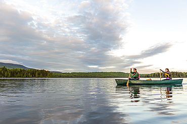 A Young Couple Paddles A Canoe On Long Pond In Maine's North Woods Near Greenville, Maine