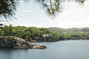 Young Woman Standing On A Rock In The Middle Of George Lake