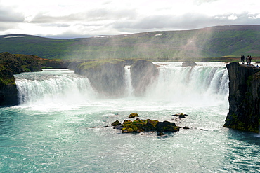 Distant View Of A People Exploring Godafoss Waterfall In Iceland