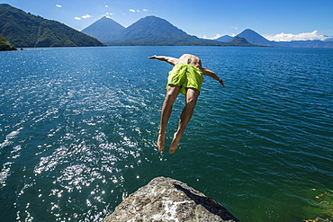 Athletic Man Backflipping In Lake Atitlan In Guatemala