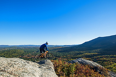 Mountain Biker On The Edge Of Bare Granite Slabs In New Hampshire