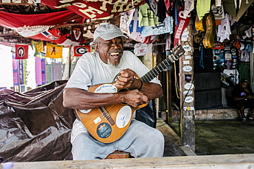 Portrait Of Smiling Man With Guitar Sitting In The Island Of Jost Van Dyke, British Virgin Islands