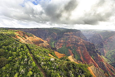 A Road Leads Past Waimea Canyon And Waipoo Falls On The Hawaiian Island Of Kauai