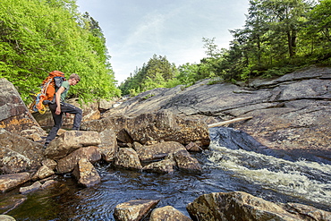 A Rock Climber Crossing A Stream In New York