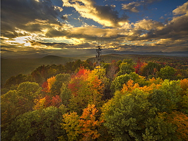 Fire Lookout Tower Surrounded By Autumn Trees With Adirondack Mountains In Background