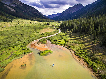 Aerial view of a small mountain river with mountains in the distance