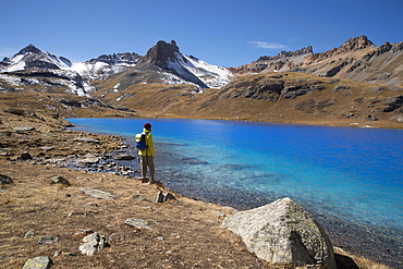 Young male stands at Ice Lake in the San Juan mountains of southern Colorado during a sunny fall afternoon