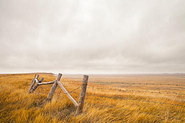 A section of a fence overlooks the plains of South Dakota, United States.