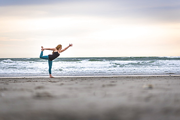 A Woman Doing Yoga On Cloudy Day At The Beach In Rhode Island