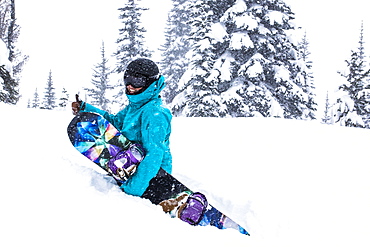 A Female Snowboarder Hikes Through Waist Deep Snow And Gives A Thumbs Up At Whistler Blackcomb Ski Resort