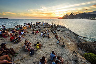 Locals and tourists watching the sunset from Arpoador Rock in Ipanema Beach, Rio de Janeiro, Brazil