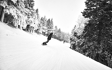 A snowboarder riding down a trail at Killington, VT.