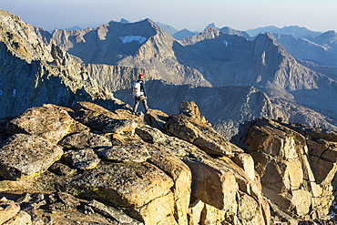 A man hiking along the summit of Mount Mendel along the 8.5 mile Evolution Traverse, John Muir Wilderness, Kings Canyon National Park, Bishop, California.