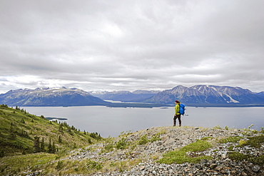 Female hiker on Monarch Mountain overlooking Atlin Lake towards the Boundary Mountain Ranges British Columbia