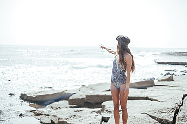 girl in a swimsuit and diving googles playing with the waves on the beach