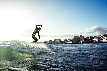 A man surfs a small wave on his longboard