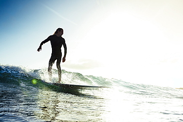 A man surfs a small wave on his longboard