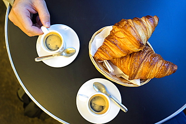 Espresso and Croissants in a basket on a table at a brasserie in Saint Michel, Paris, France