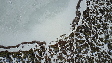 aerial view of pond and surrounding wetlands in winter.