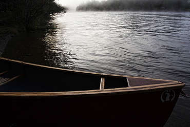 A canoe along teh side of a river in Maine.