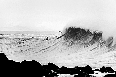 A surfer stepping over the ledge on a big wave at Waimea Bay, on the north shore of Oahu.