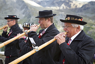 Four traditionally dressed locals playing alphorn, Zermatt, Valais, Switzerland