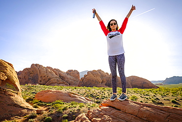 Woman standing in celebratory pose, Valley of Fire State Park, Nevada, USA