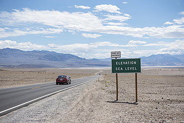 Car driving on road in Death Valley National Park at sea level, California, USA