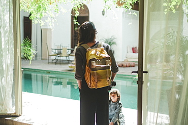 Photograph with mother with son standing by swimming pool in Moroccan riad, Marrakech, Morocco