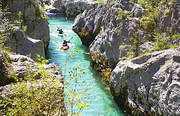 Kayakkers on the emerald Soca near Bovec in Slovenia. This green colored river, originating in the Triglav mountains, is famous for all kinds of white water activities.