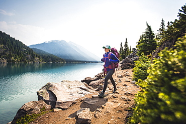 Woman hiking along shore of Lake Garibaldi, British Columbia, Canada