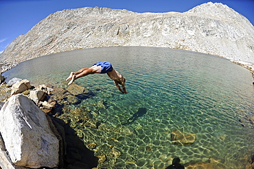 Man diving into La Salle Lake while hiking on a two-week trek of the Sierra High Route in the John Muir Wilderness in California. The 200-mile route roughly parallels the popular John Muir Trail through the Sierra Nevada Range of California from Kings Canyon National Park to Yosemite National Park.