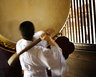 A man ready to strike a taiko (a great or fat drum). Tokyo, Japan.