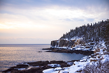 Scenic view of Otter Cliffs covered with snow at sunrise, Acadia National Park, Maine, USA