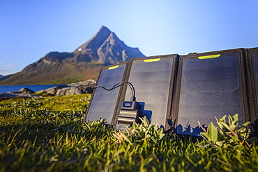 Solar charger lying in grass in front of mountain