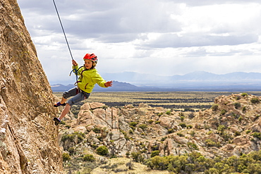 A girl rock being lowered down a cliff face after rock climbing on the Trad Wall, Isle of You, Cochise Stronghold, Tombstone, Arizona, USA