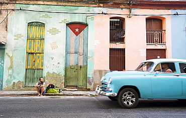 Side view of male tourist sitting on street of Havana, Cuba