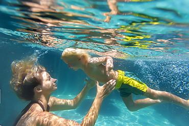 Underwater view of mother and son swimming in swimming pool