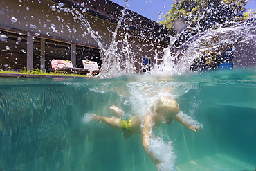 Underwater view of boy swimming in pool after diving into water