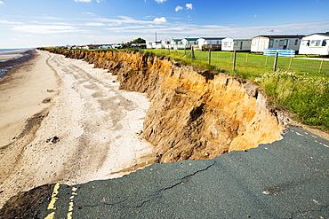 A collapsed coastal road at between Skipsea and Ulrome on Yorkshires East Coast, near Skipsea, UK. The coast is composed of soft boulder clays, very vulnerable to coastal erosion. This section of coast has been eroding since Roman times, with many villages having disappeared into the sea, and is the fastest eroding coast in Europe. Climate change is speeding up the erosion, with sea level rise, increased stormy weather and increased heavy rainfall events, all playing their part.