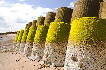 Smashed concrete sea defenses at Ulrome near Skipsea on Yorkshires East Coast, UK. The sea has eroded past the barriers and left them stranded further down the beach. The coast is composed of soft boulder clays, very vulnerable to coastal erosion. This section of coast has been eroding since Roman times, with many villages having disappeared into the sea, and is the fastest eroding coast in Europe. Climate change is speeding up the erosion, with sea level rise, increased stormy weather and increased heavy rainfall events, all playing their part.