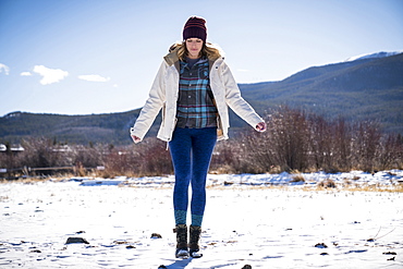 Front view full length shot of single woman walking outdoors in winter