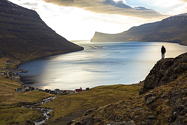 Distant view of man standing on seashore, Faroe Islands, Denmark