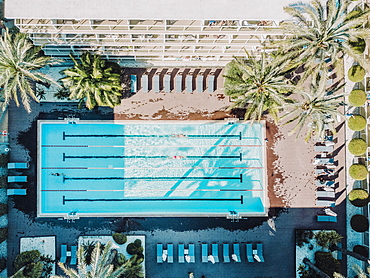 Aerial view of swimmers in hotel swimming pool at daytime, Mallorca, Balearic Islands, Spain