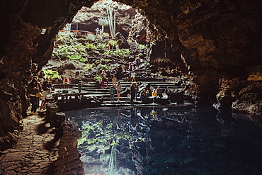 Tourist visiting cave and lake inside Jameos del Agua, Lanzarote, Canary Islands, Spain