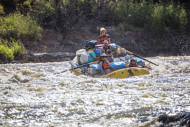 Men and women rafting on rushing Green River in Desolation Canyon, Utah, USA