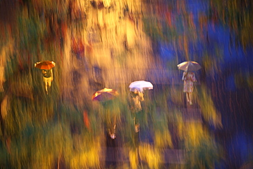 Blurred image of people walking in rain in Central Park, New York City, New York, USA