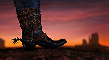 Cowboy boot and Mittens in distance at sunset, Monument Valley, Arizona, USA