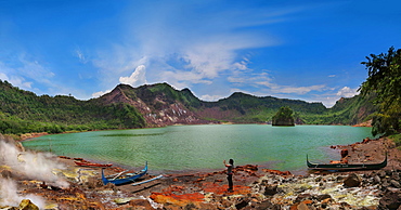 Woman taking picture in front of Taal Volcano crater lake and mountains, Tagaytay, Batangas, Philippines